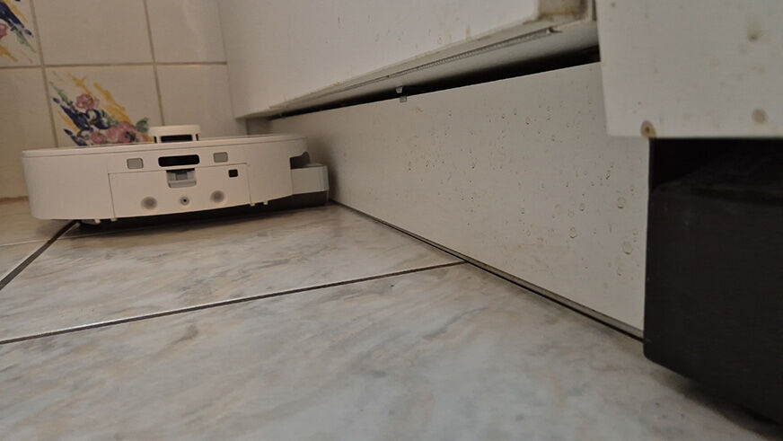 Der Qrevo Curv 2 Flow wischt entlang einer Fußleiste mit ausfahrbarer Walze.